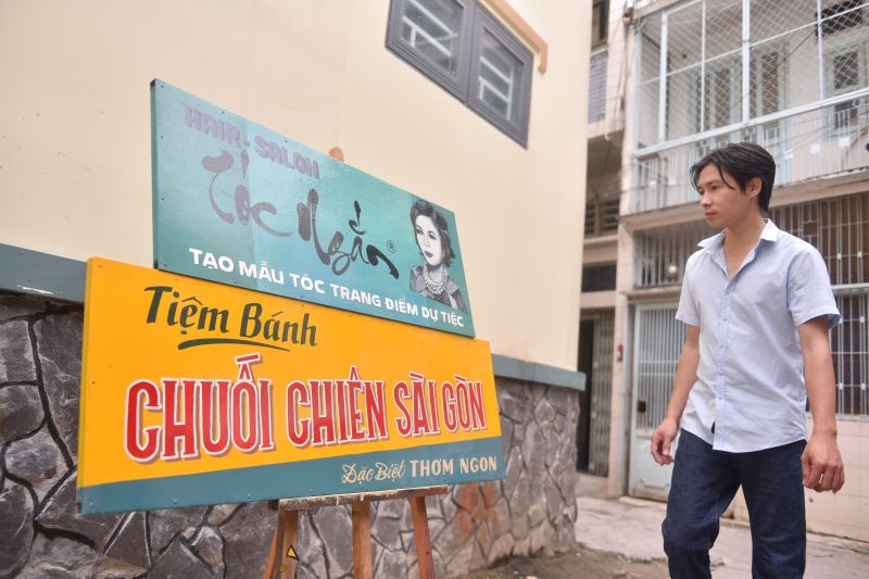 ヘアサロンと友人のバナナ店の看板を乾かすバオさん　ⓒ TuoiTre